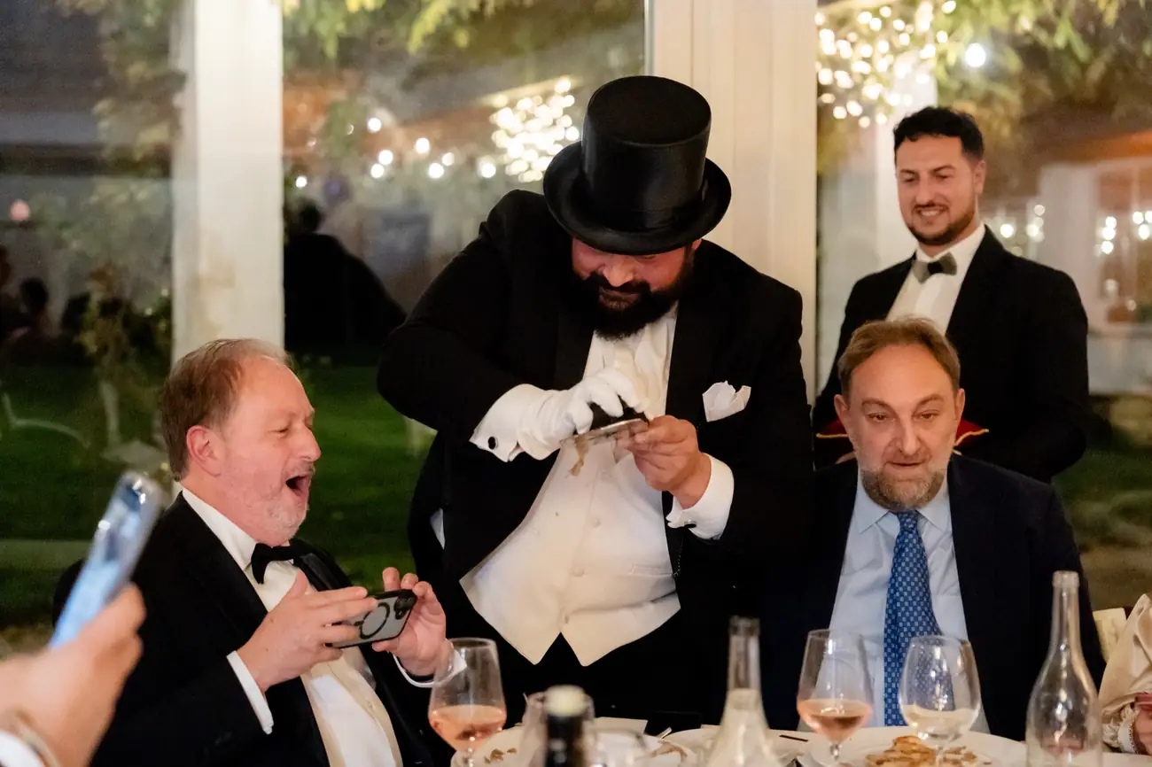 Il Lord in tuba lamella il Tartufo al tavolo, gli Ospiti ridono